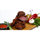 Slices of smoked homemade lamb pastrami from DELUMANI, showcasing thin, flavorful meat on a wooden board.